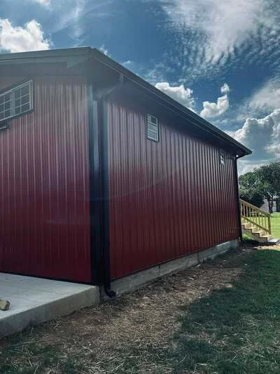 Concrete pad foundation for metal agricultural building with corrugated siding