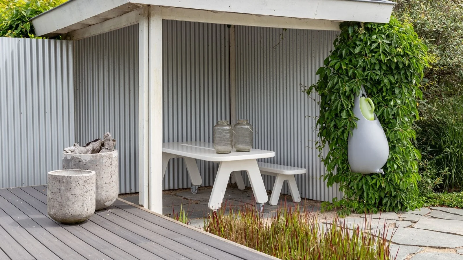 Textured concrete planters and vessels on composite deck with stone patio edging