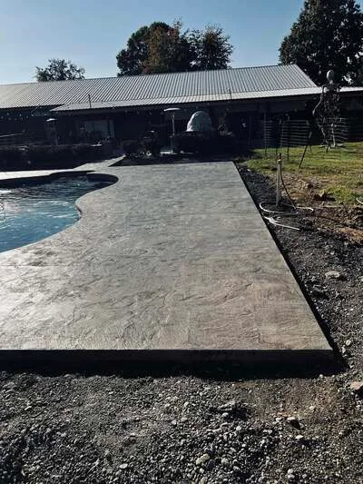 Stamped concrete pool deck with decorative finish and black border edging